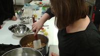 Stirring the apple, sugar, and spice mixture over heat until it gels